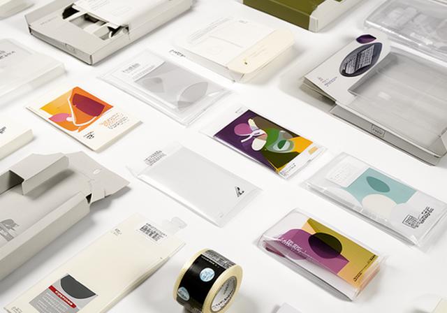 Fulfilment packaging samples including custom inserts, mailers, and tape rolls arranged for review